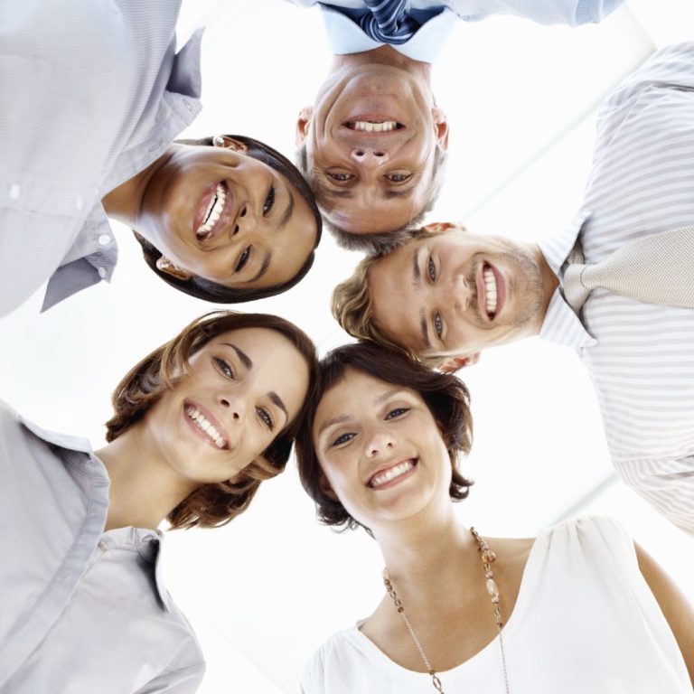 Fragen und Antworten Fünf Menschen lächeln und schauen von unten nach oben in die Kamera.